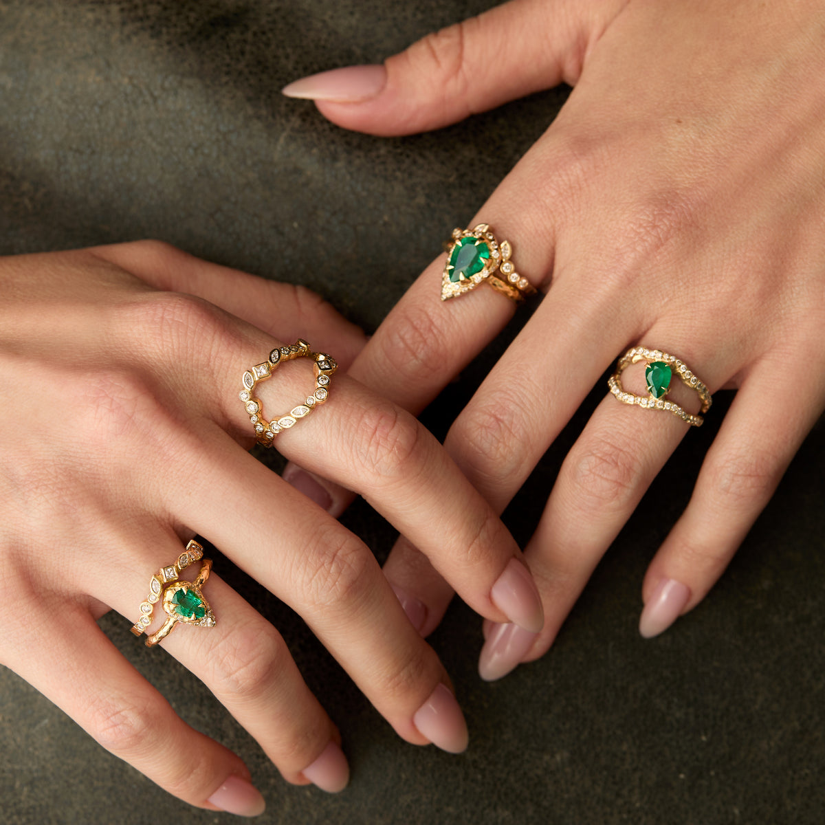 Mystic emerald and diamond ring with a 0.70 ct pear-shaped natural emerald and sculptural 14K yellow gold setting worn on hand with adama diamond rings and pear shaped emerald rings