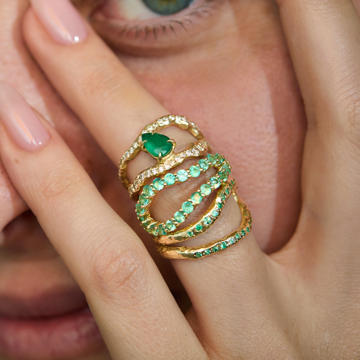 14K gold emerald ring showing the open sculptural twin bands and hand-carved organic texture and emerald infinity rings worn on hand