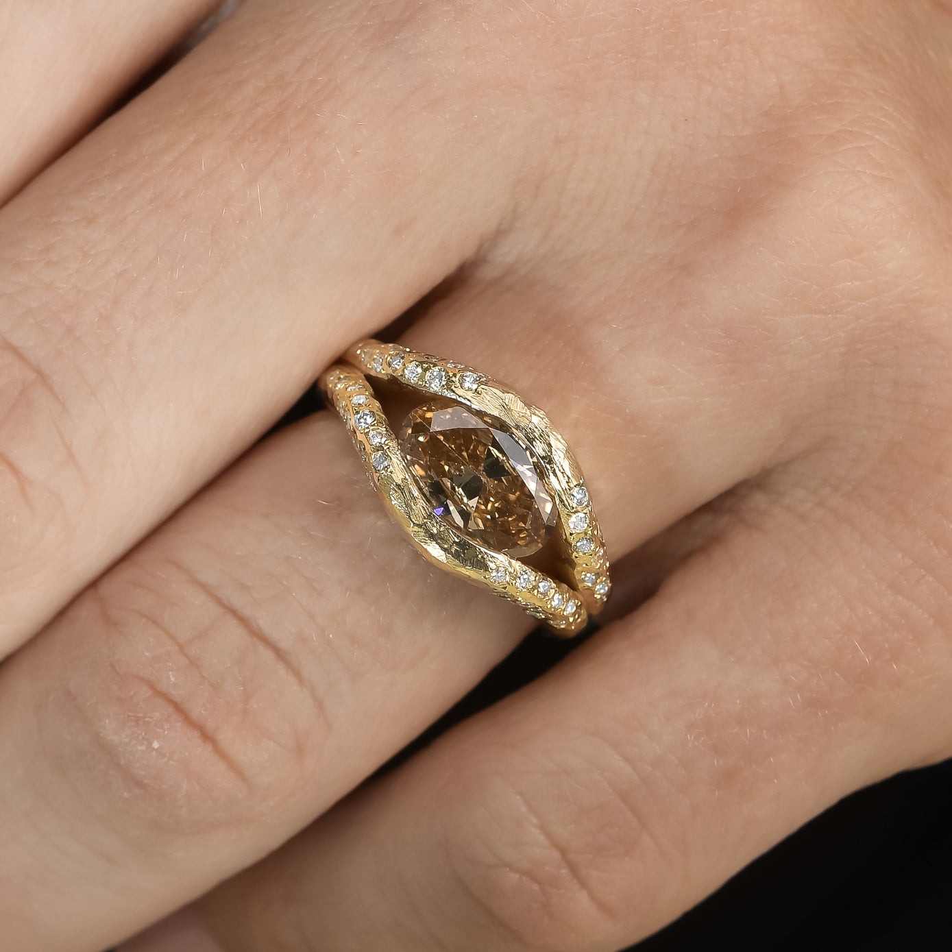 Oval champagne diamond halo ring in textured 14K gold with a floating diamond effect and diamond halo