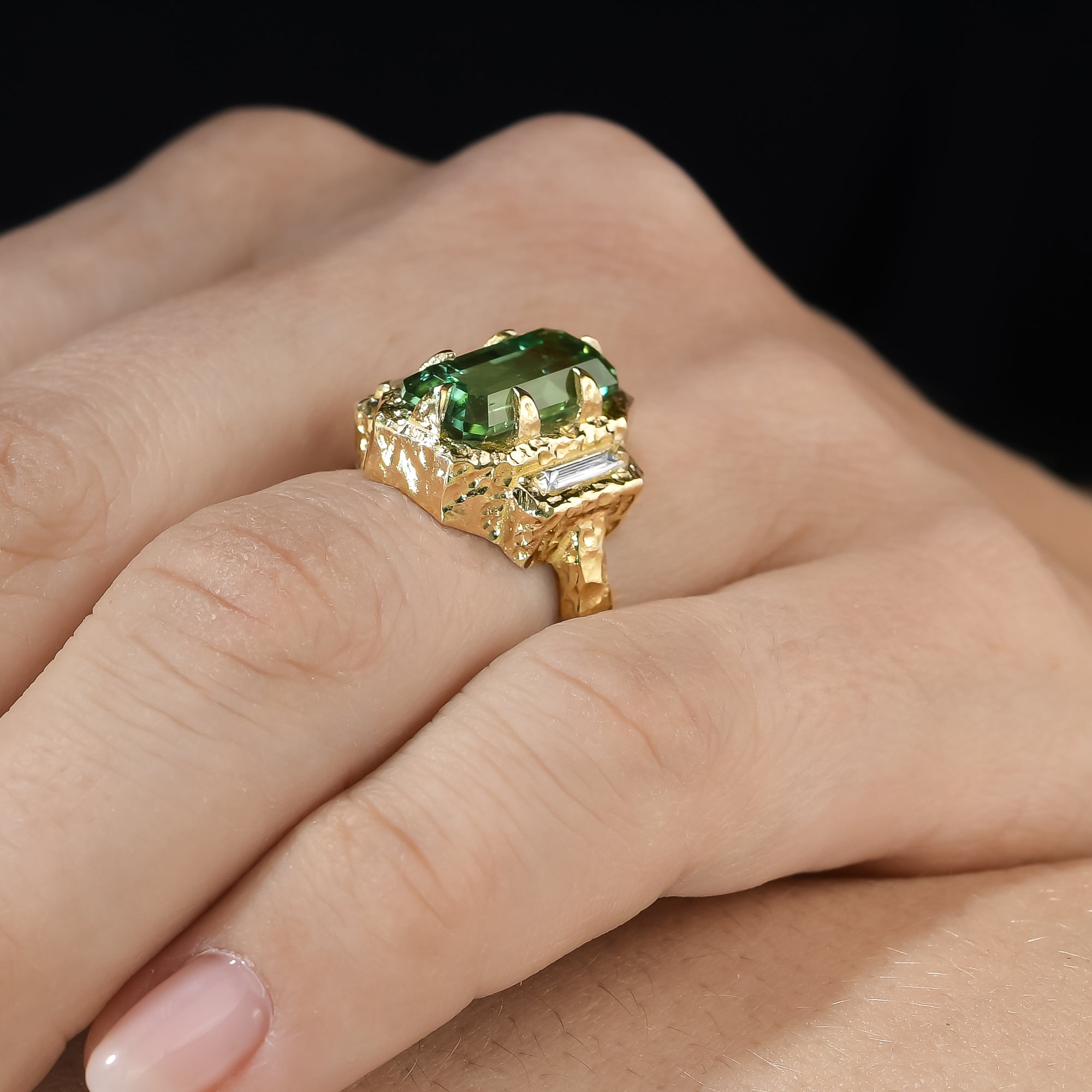 Side view of lagoon tourmaline and baguette diamond ring showing the hand-carved 14K yellow gold setting.
