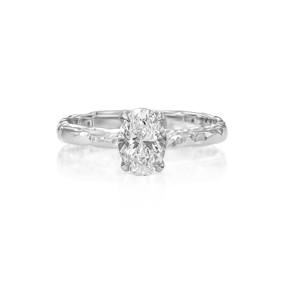 Angled view of 1 ct natural oval diamond engagement ring with hand-carved textured 14K white gold band.