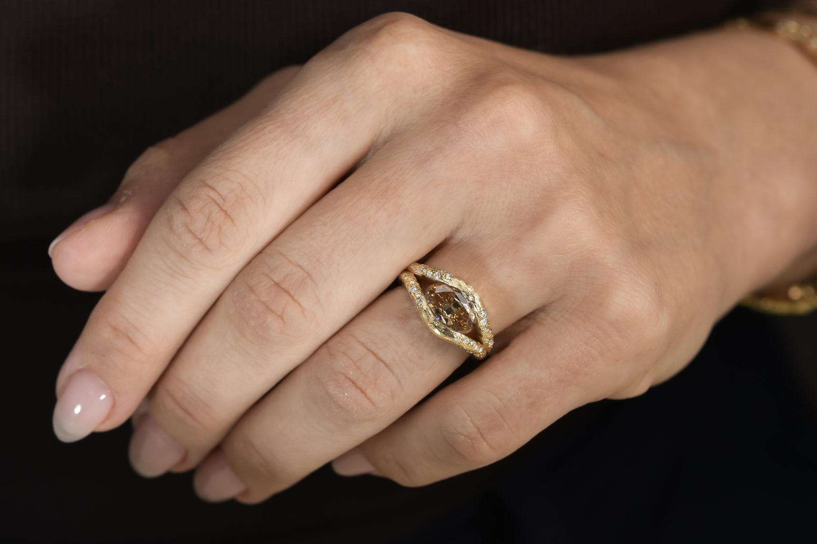 Oval champagne diamond halo ring in textured 14K gold with a floating diamond effect and diamond halo