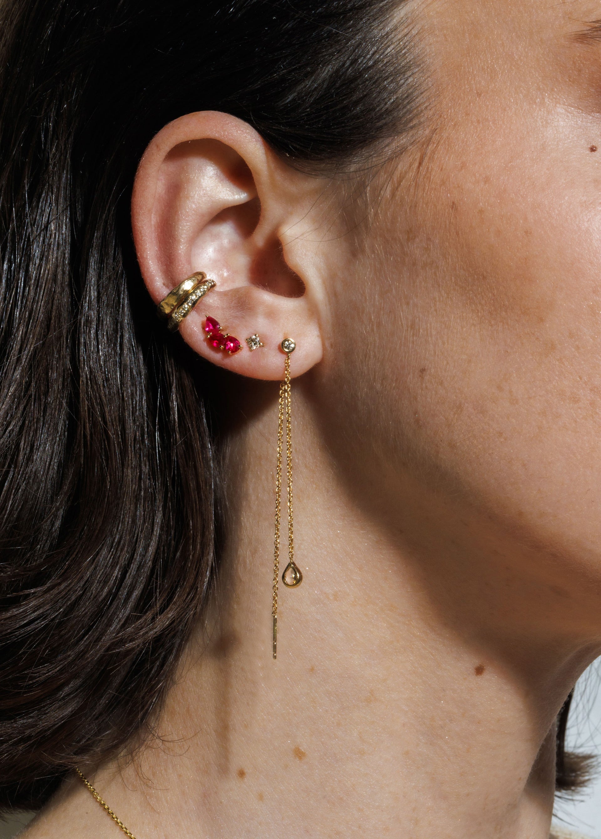 14K gold Venus earring featuring a round bezel-set diamond stud and a graceful single chain drop in a high polish finish.