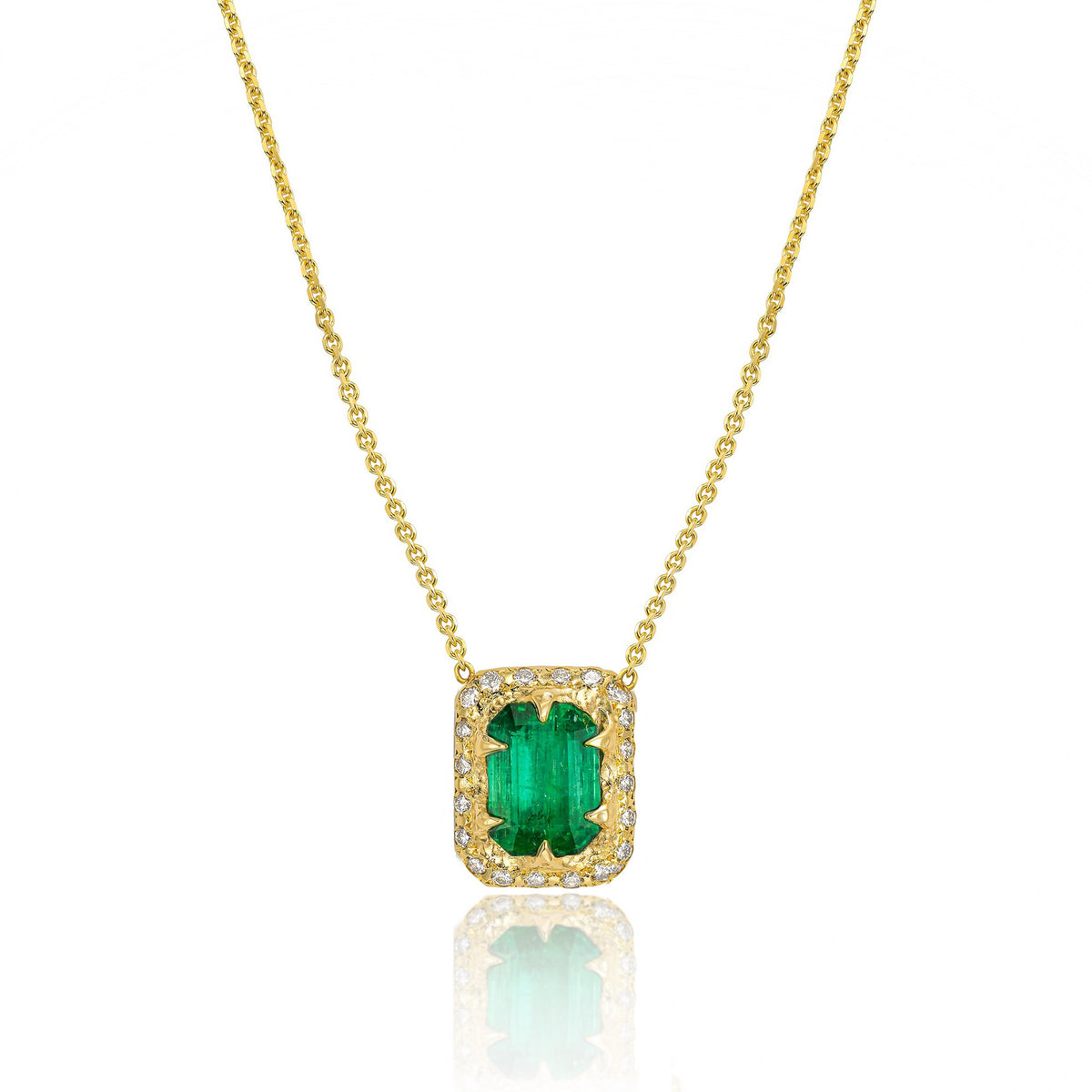 Front view of emerald-cut green emerald set lengthwise in a textured 14K yellow gold pendant surrounded by a diamond halo.