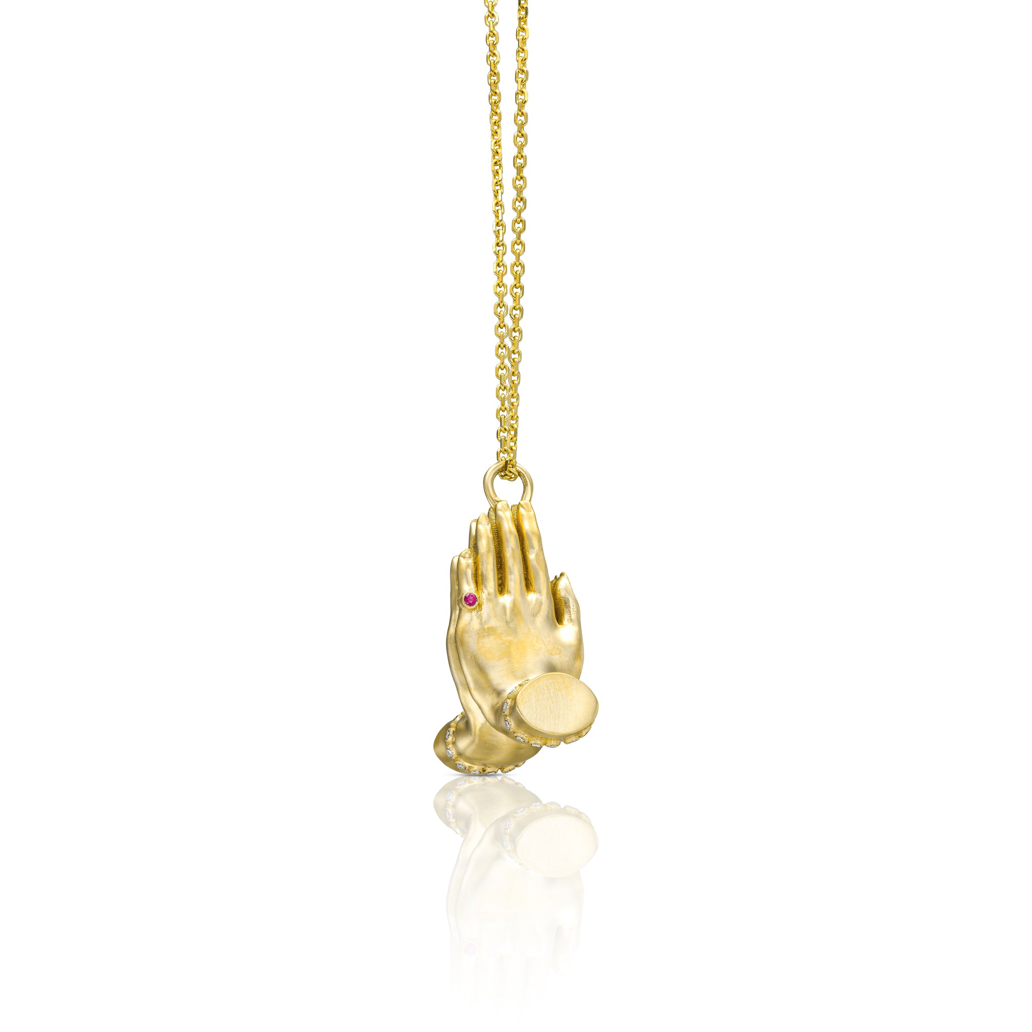 Sculptural gold Namaste pendant with diamond details, natural emerald and ruby on a fine gold chain.