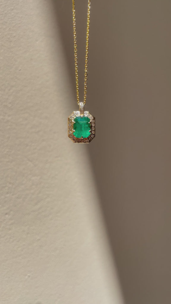 Emerald-cut natural emerald and diamond necklace in hand-carved 14K yellow gold, featuring a deep green center stone surrounded by natural diamonds.