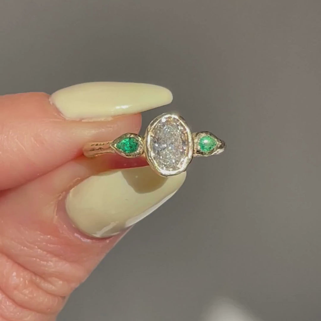Oval diamond and pear emeralds engagement ring in 14K yellow gold with hand-carved organic texture