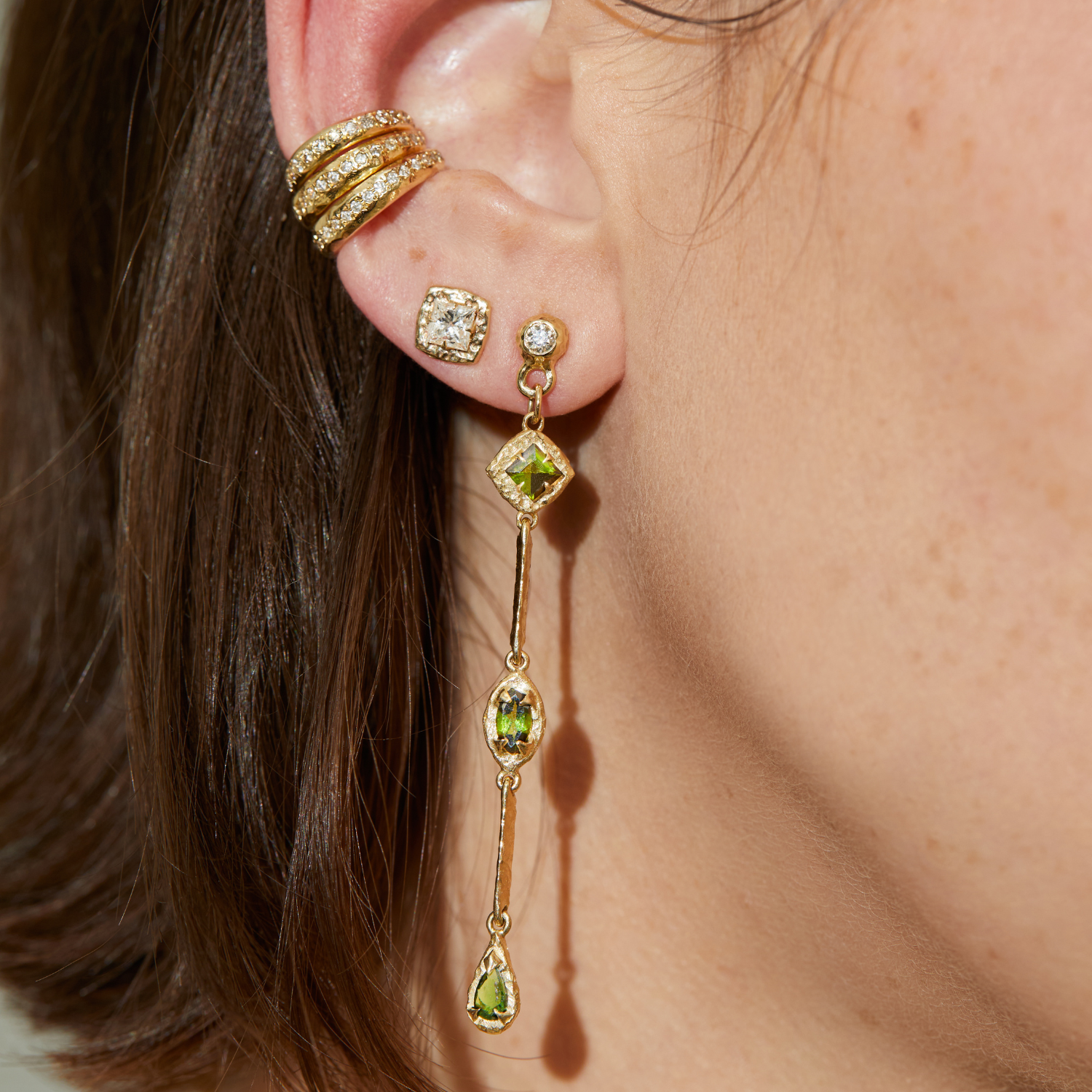 Princess-cut diamond studs in 14K gold styled on the ear