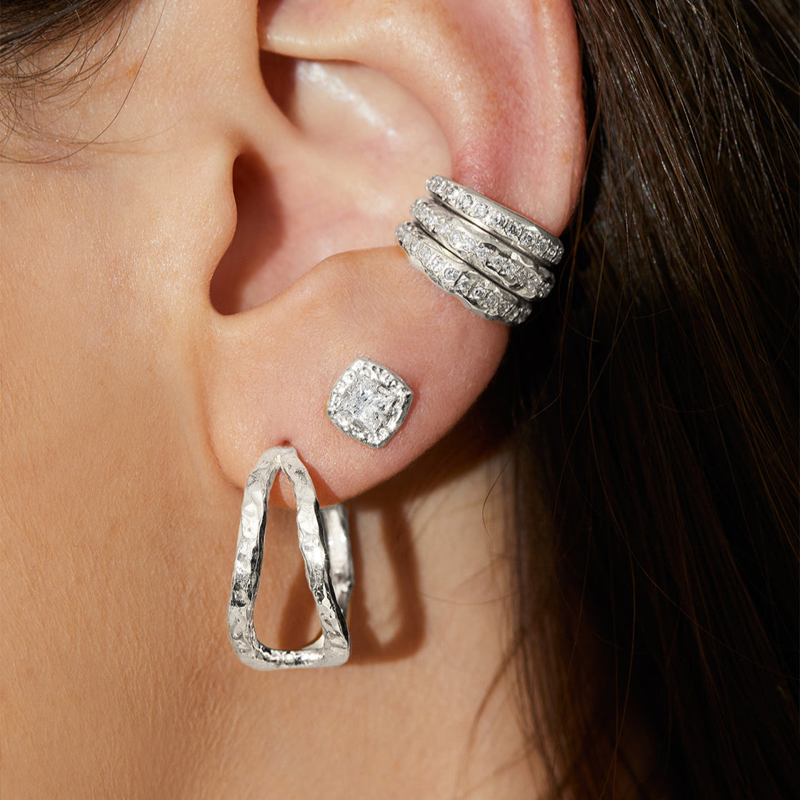 Close-up of an ear wearing princess cut diamond stud earrings in 14K white gold